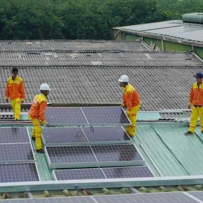 Workers installing solar panels on a roof for sustainable energy solutions.